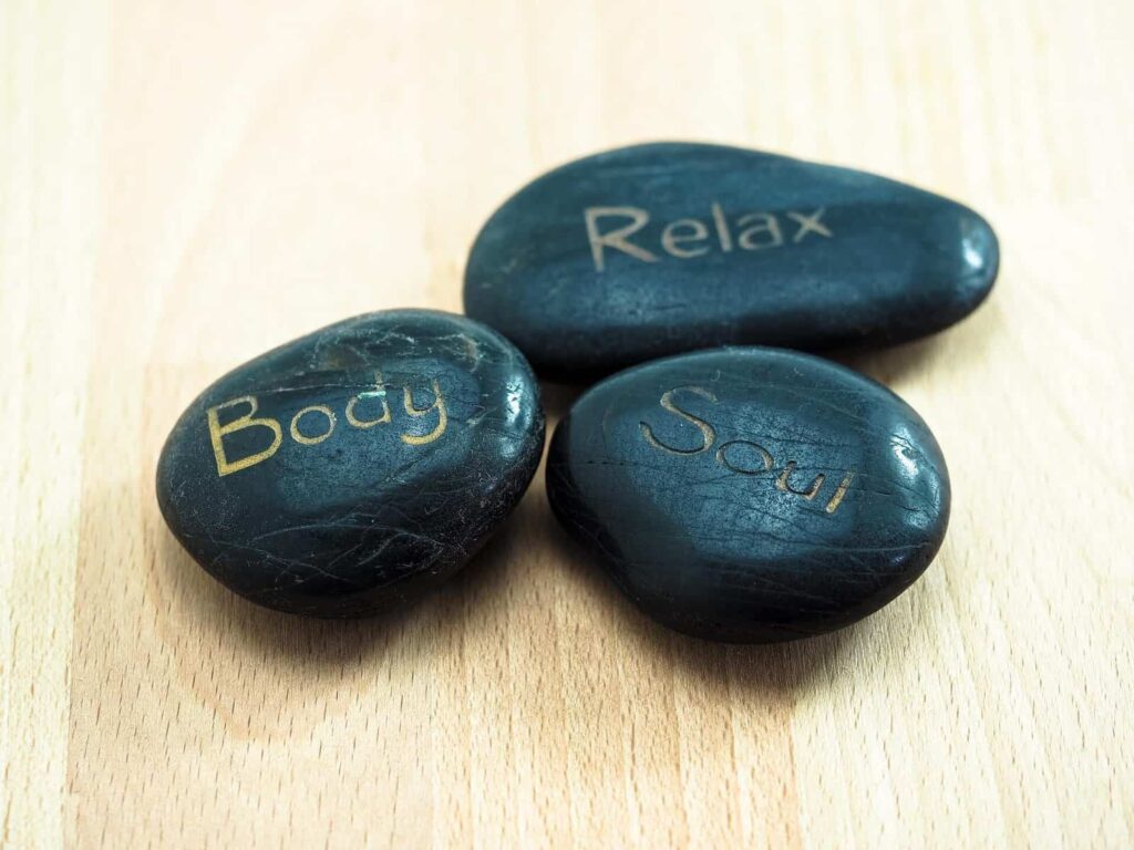 Three stones with words engraved, body, relax and soul. Three words to sum up progressive relaxation.